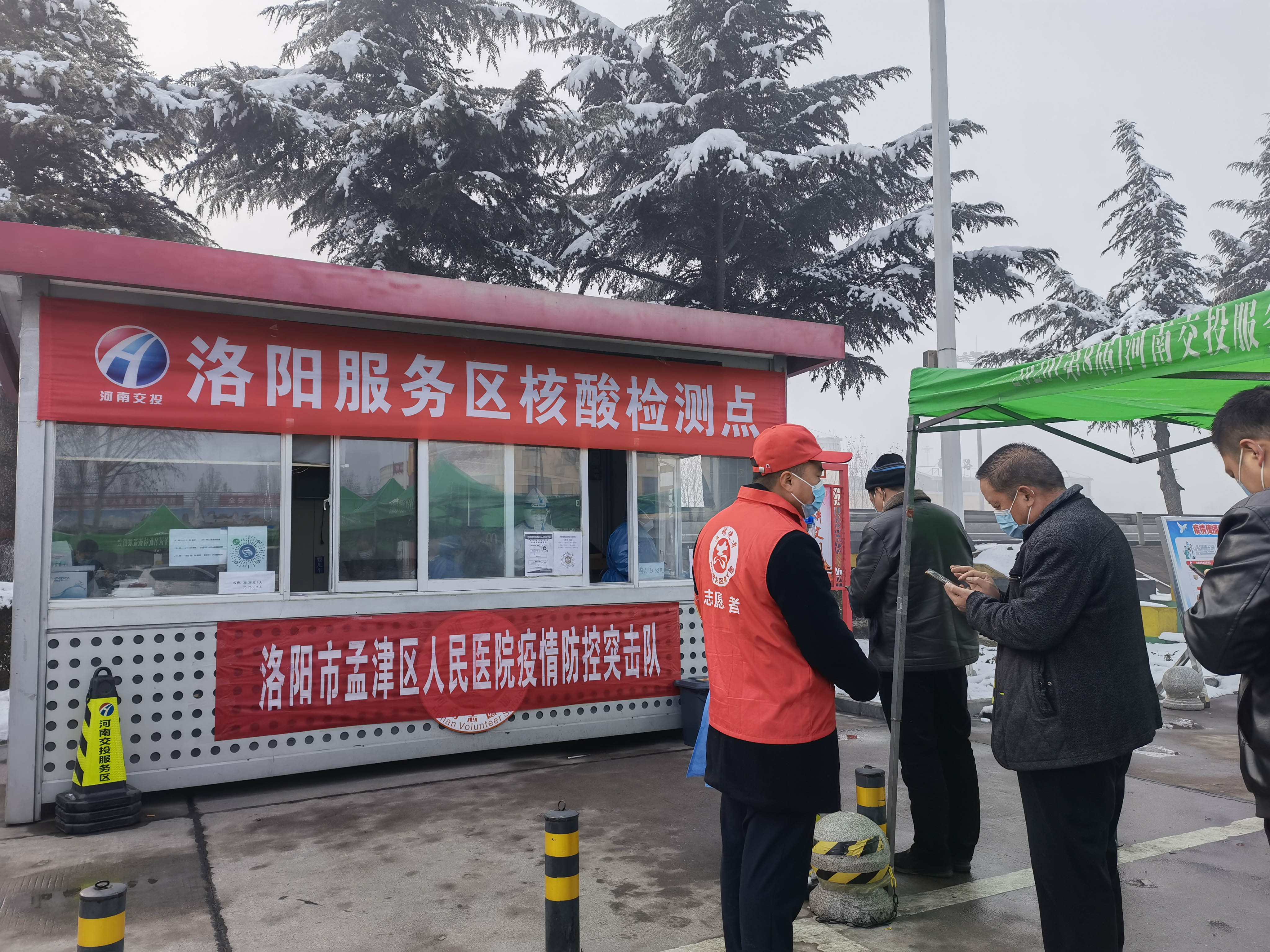 1月25日，洛陽服務區黨員志愿者為指引司乘人員填寫核酸檢測信息。 周黃偉 攝.jpg